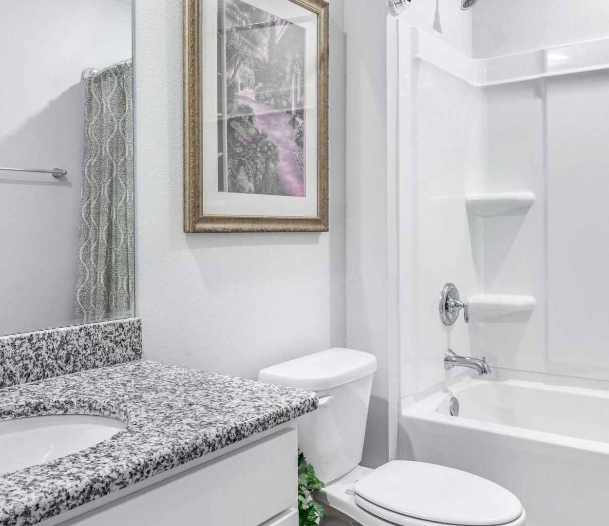 Bright and clean modern bathroom with granite countertop and elegant decor.
